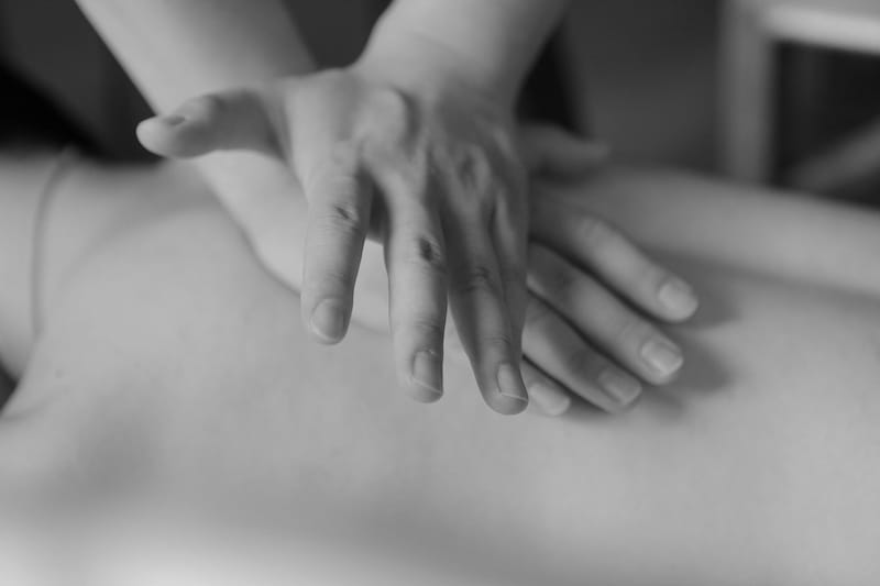 Massage des tissus profonds : mains appliquant une pression lente et profonde sur le dos